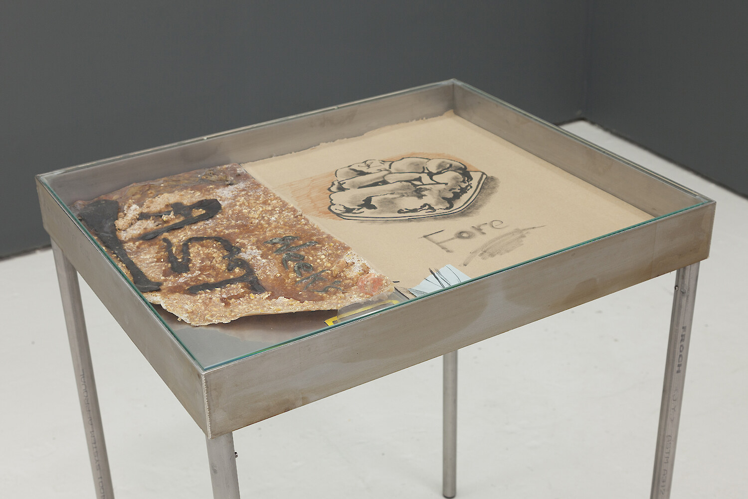 *Fore* (detail view), 2016, Stainless steel vitrine table, Polymer clay, Latex, Couscous, Corn, Plaster, Plastecine, Card, India ink, Marker, Thermal paper, Card, Slate, Steel cut tacs, 25 x 31 cm